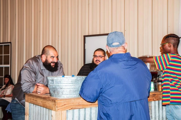 Guests gathered around the rustic drink station and galvanized tub bar