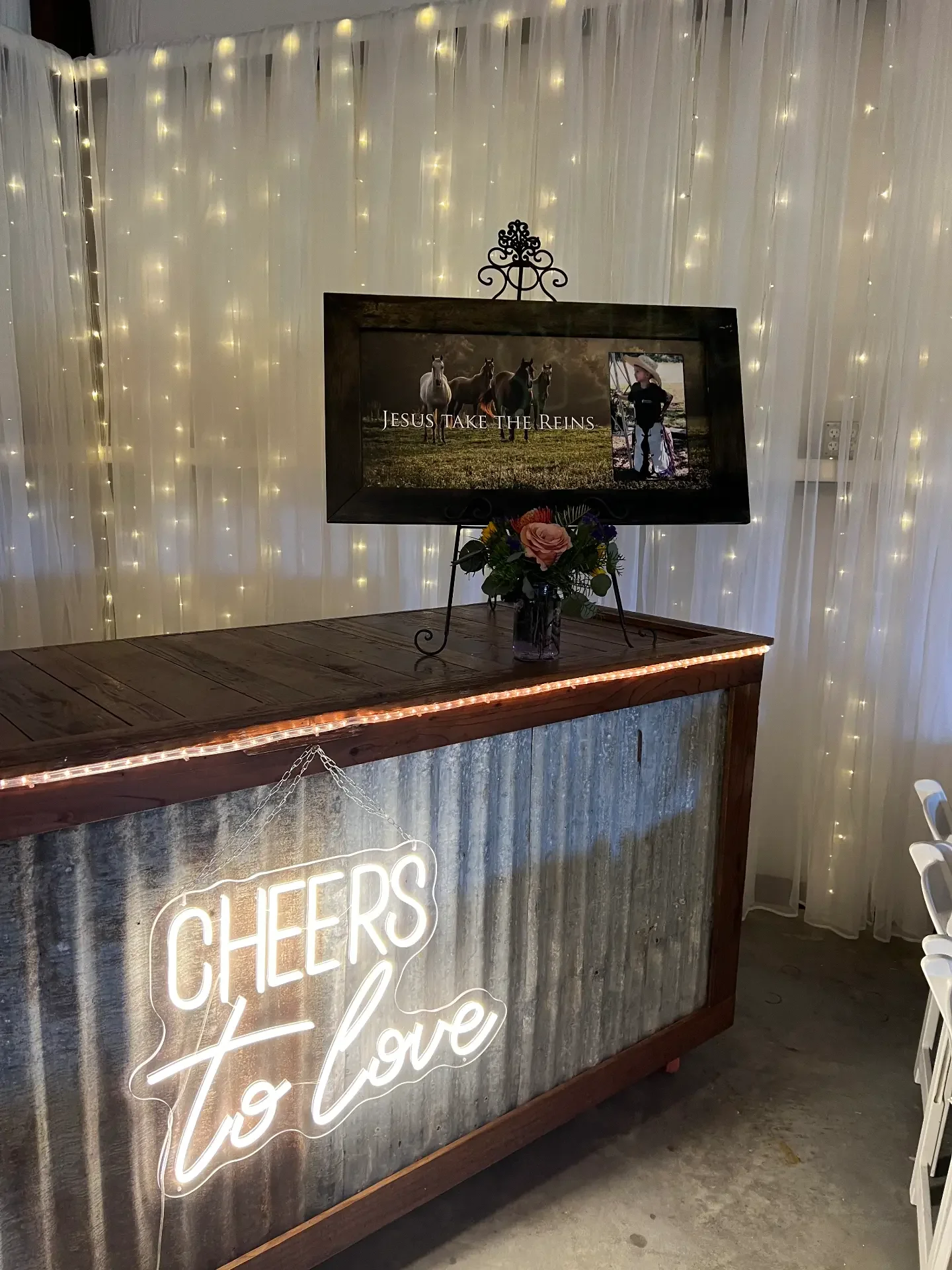 Reclaimed wood and tin bar lit with rope lighting and a glowing neon sign at the Love Like Bailin Therapy Farm event