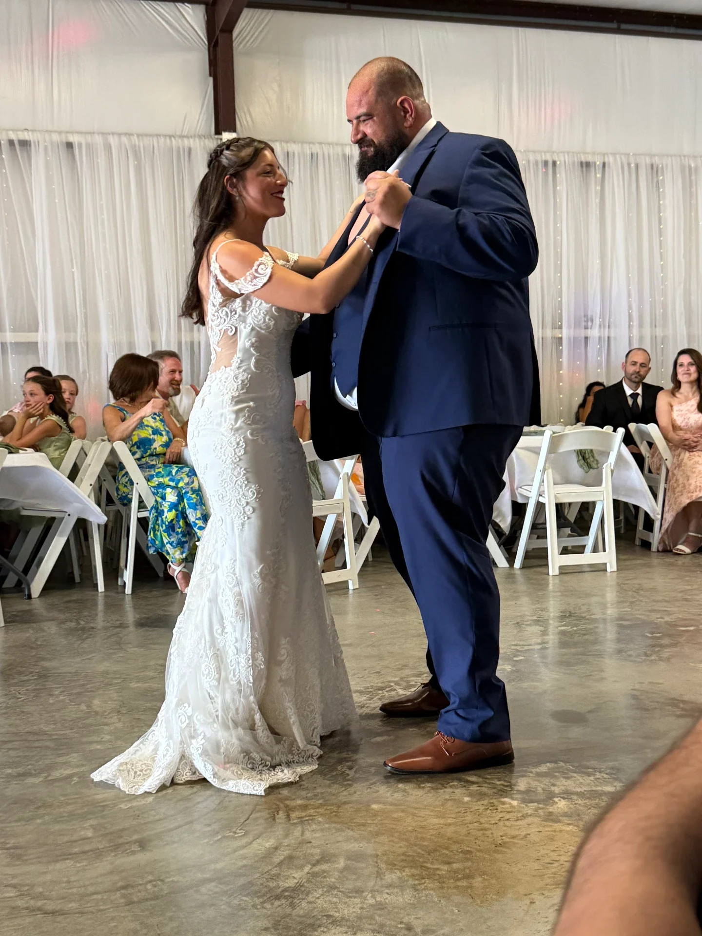 Bride dancing with her father on the reception floor in front of seated guests
