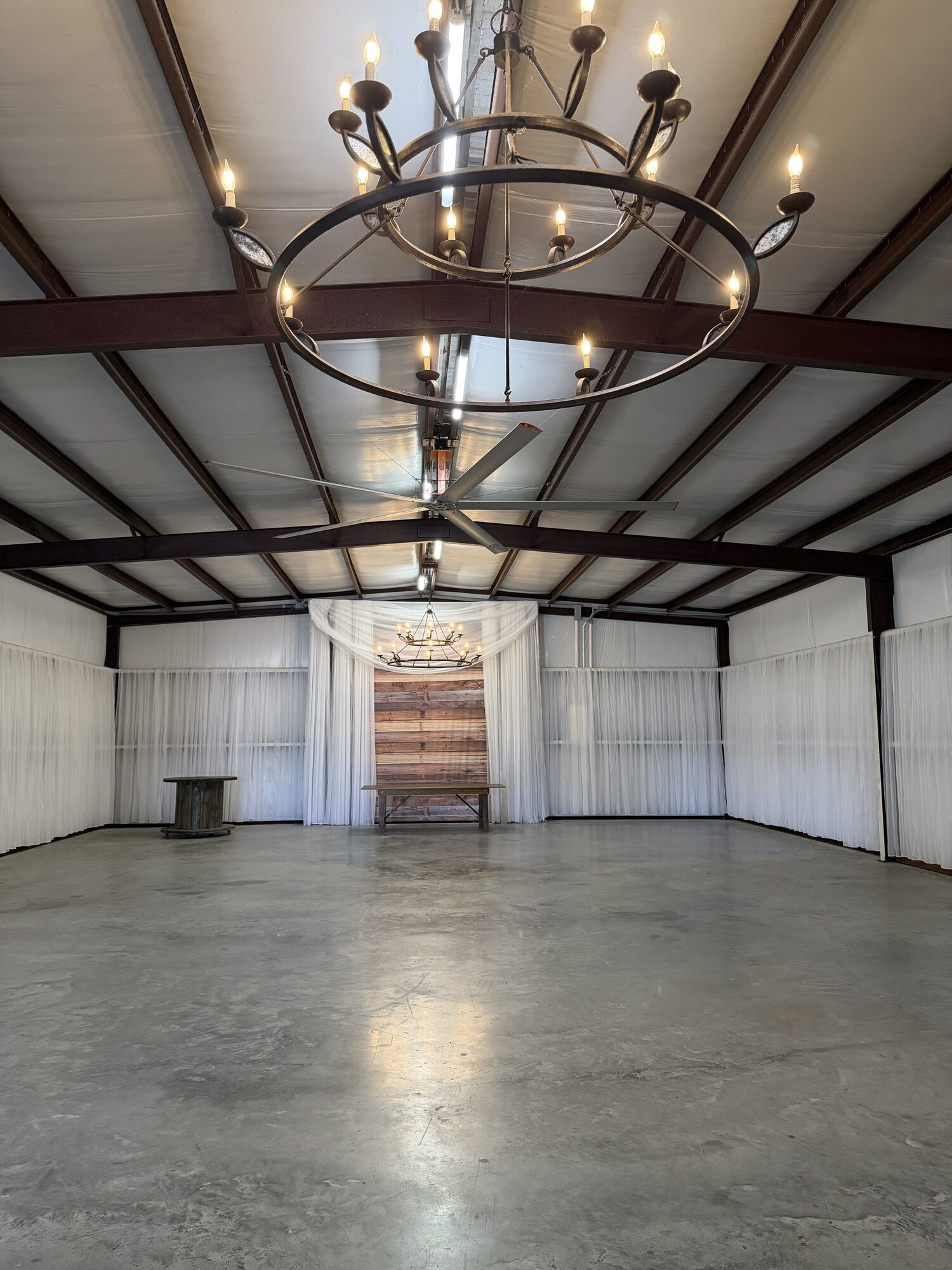 White-draped wedding barn with chandeliers at Reverie at Diamond D in Normangee, Texas