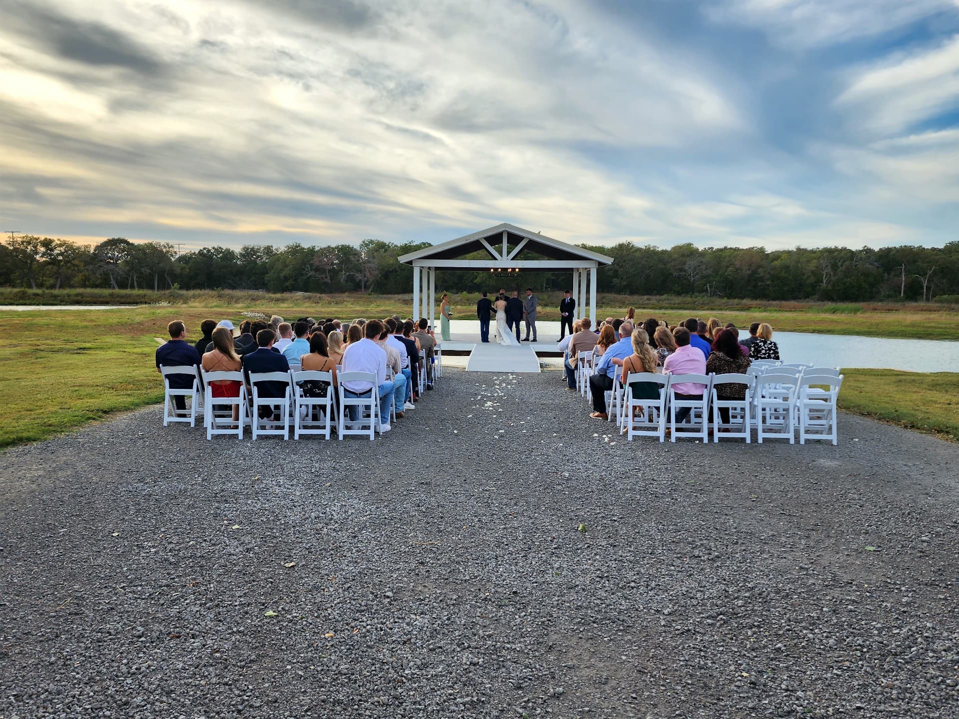 Sunset wedding ceremony beside the lake at Reverie at Diamond D in Normangee, Texas