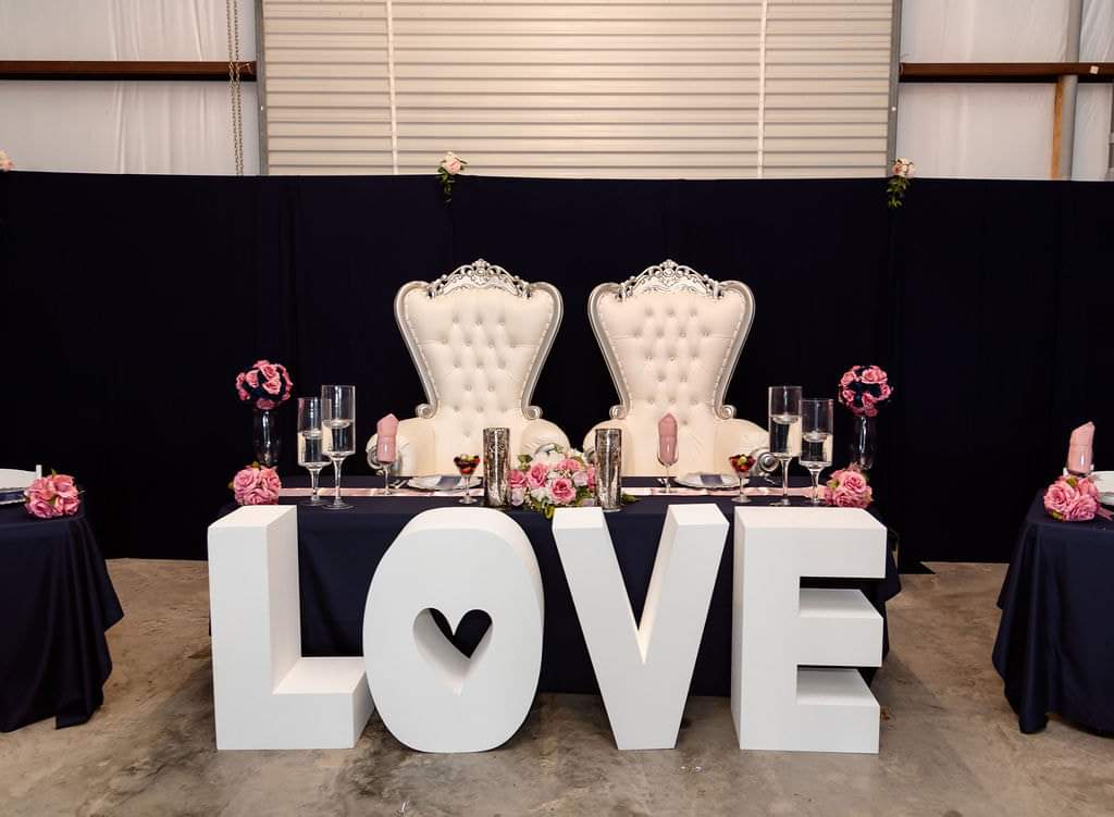 Sweetheart table with throne chairs, navy linens and giant LOVE letters