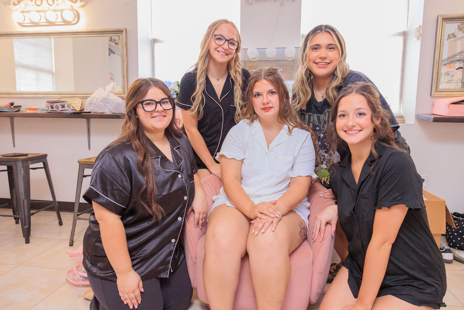 Jaelyn & Keelan's wedding at Reverie at Diamond D — the bride and her bridesmaids in matching pajamas in the bridal suite