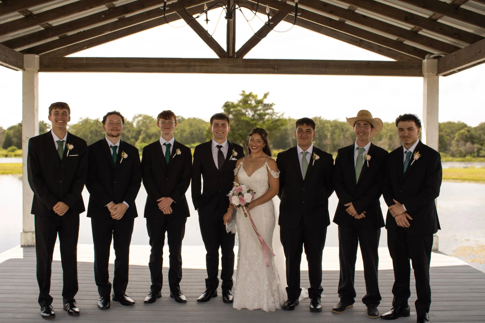 Bryanna and her wedding party under the lakeside pavilion at Reverie at Diamond D in Normangee, Texas