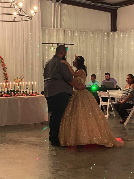 Father and daughter dancing on the reception floor beside the candle lighting table