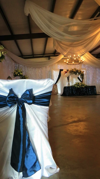 Navy satin chair sash detail with the draped reception hall in the background