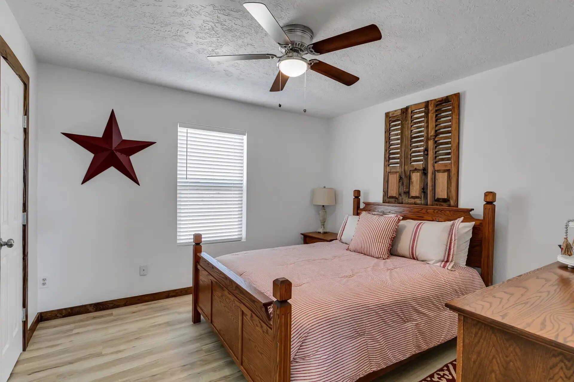 Farmhouse bedroom with Texas star wall decor and reclaimed shutter headboard at Reverie at Diamond D