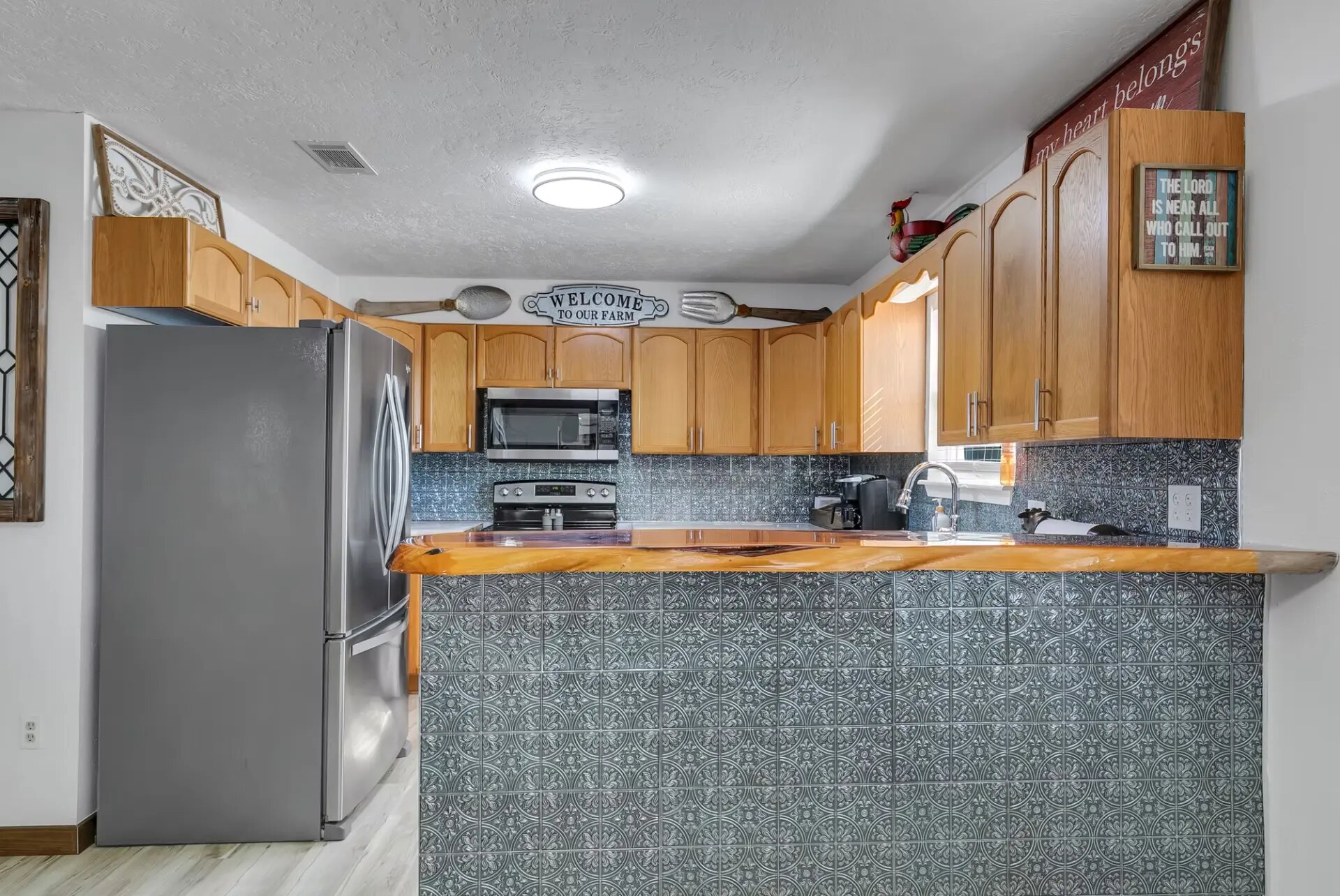 Farmhouse kitchen with live-edge bar top and full appliances at the Reverie at Diamond D vacation rental in Normangee TX