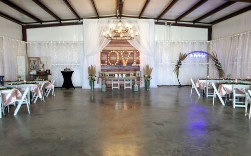 Barn reception with draped walls, marquee LOVE sign and blush linens at Reverie at Diamond D