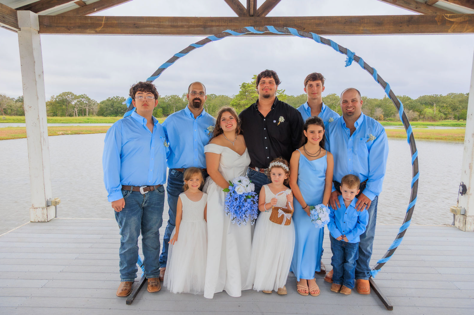 Jaelyn & Keelan's wedding at Reverie at Diamond D — family and wedding party group portrait on the pavilion deck above the lake