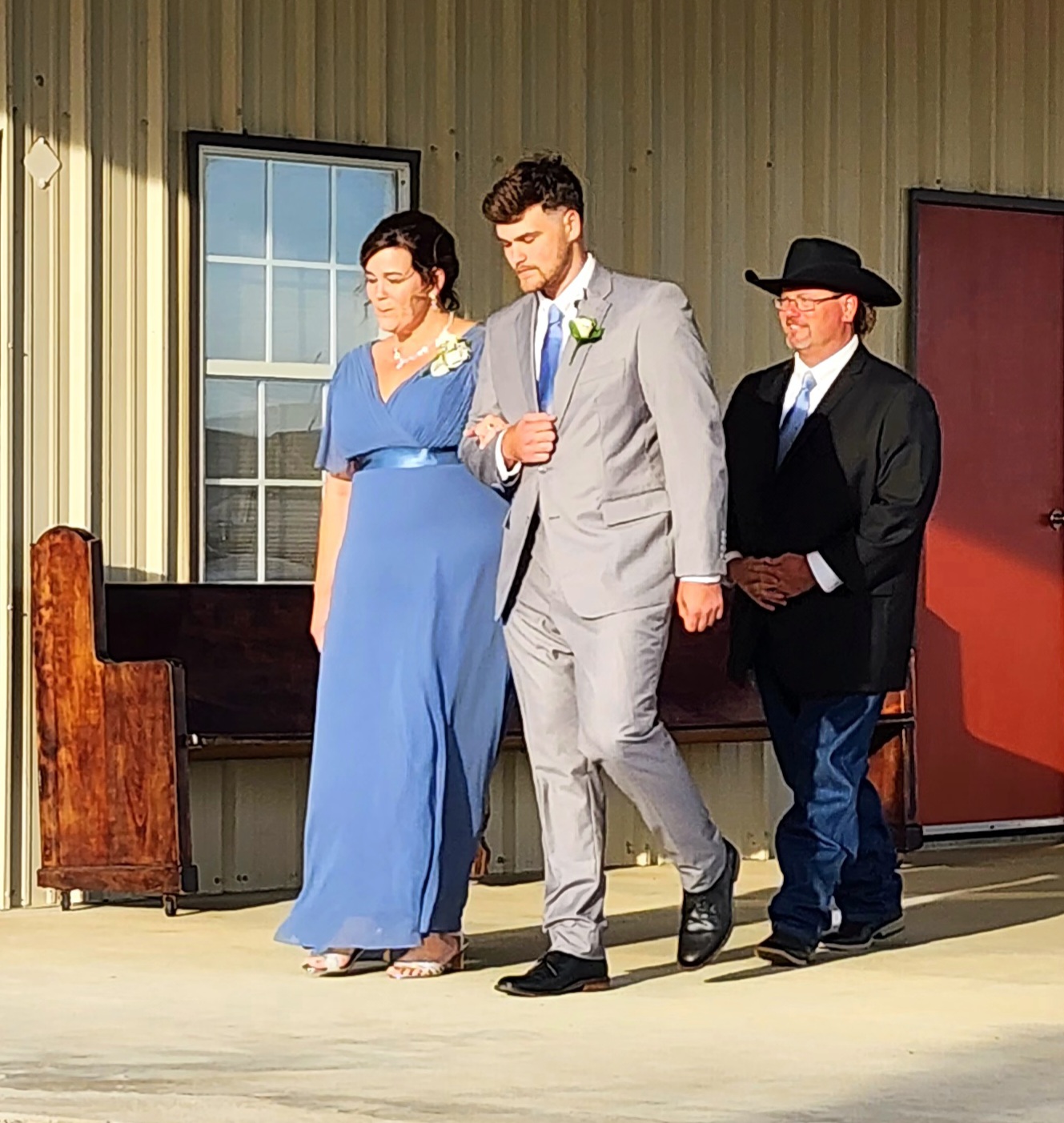 Groom escorting his mother down the barn walkway before the ceremony at Reverie at Diamond D