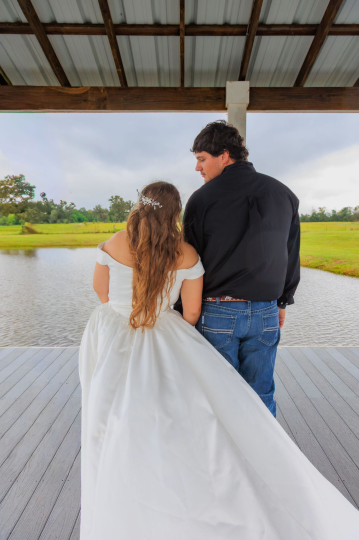 Jaelyn & Keelan's wedding at Reverie at Diamond D — the bride and groom on the pavilion deck looking out over the lake