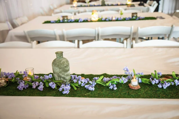 Moss table runners with lavender florals and candlelight on the reception tables