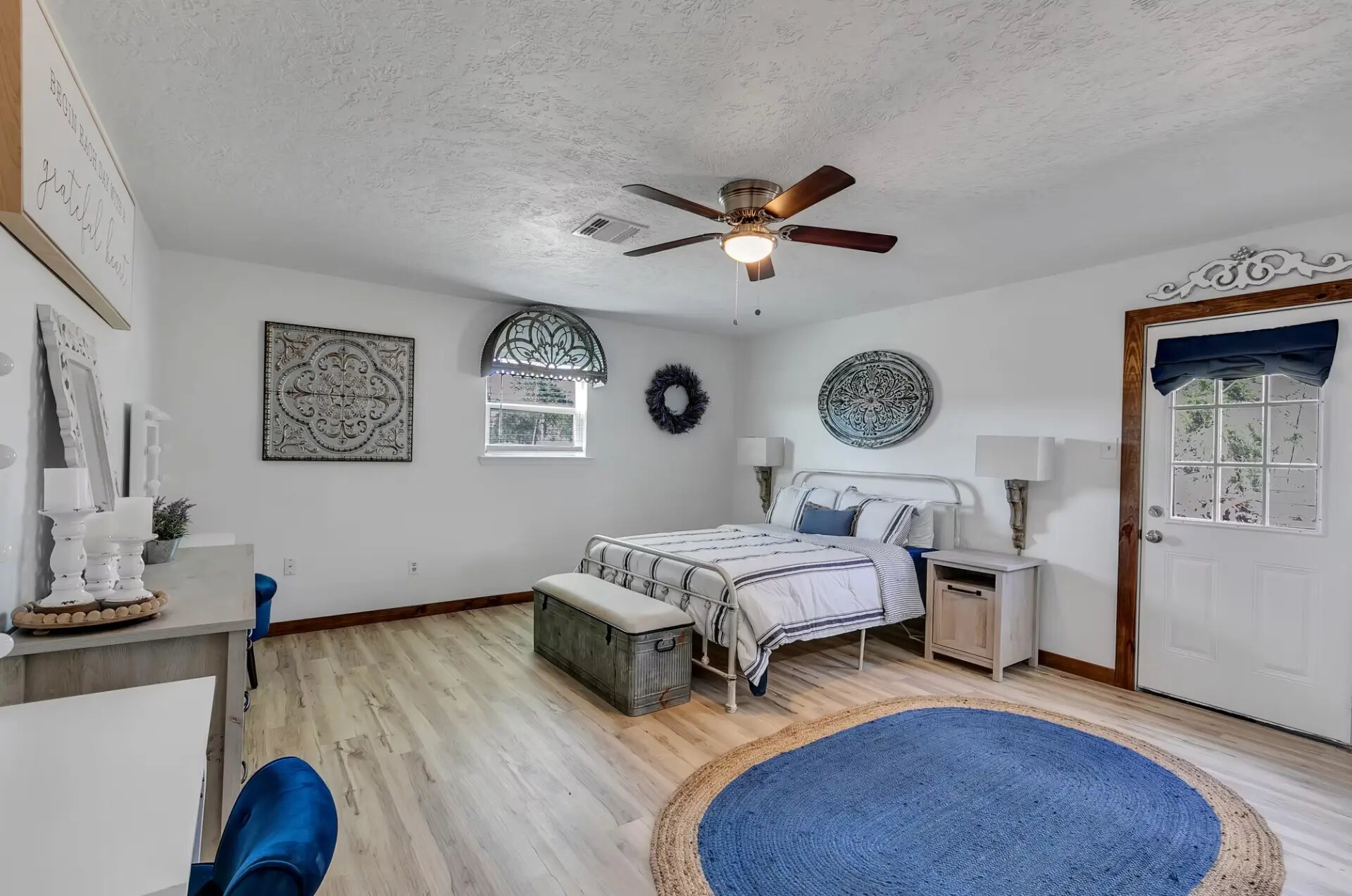 Farmhouse bedroom with vanity, iron bed and private exterior door at Reverie at Diamond D