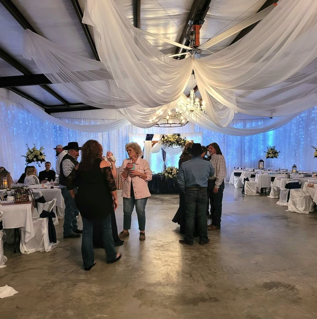 Guests mingling on the reception floor beneath draping and twinkle-light curtains