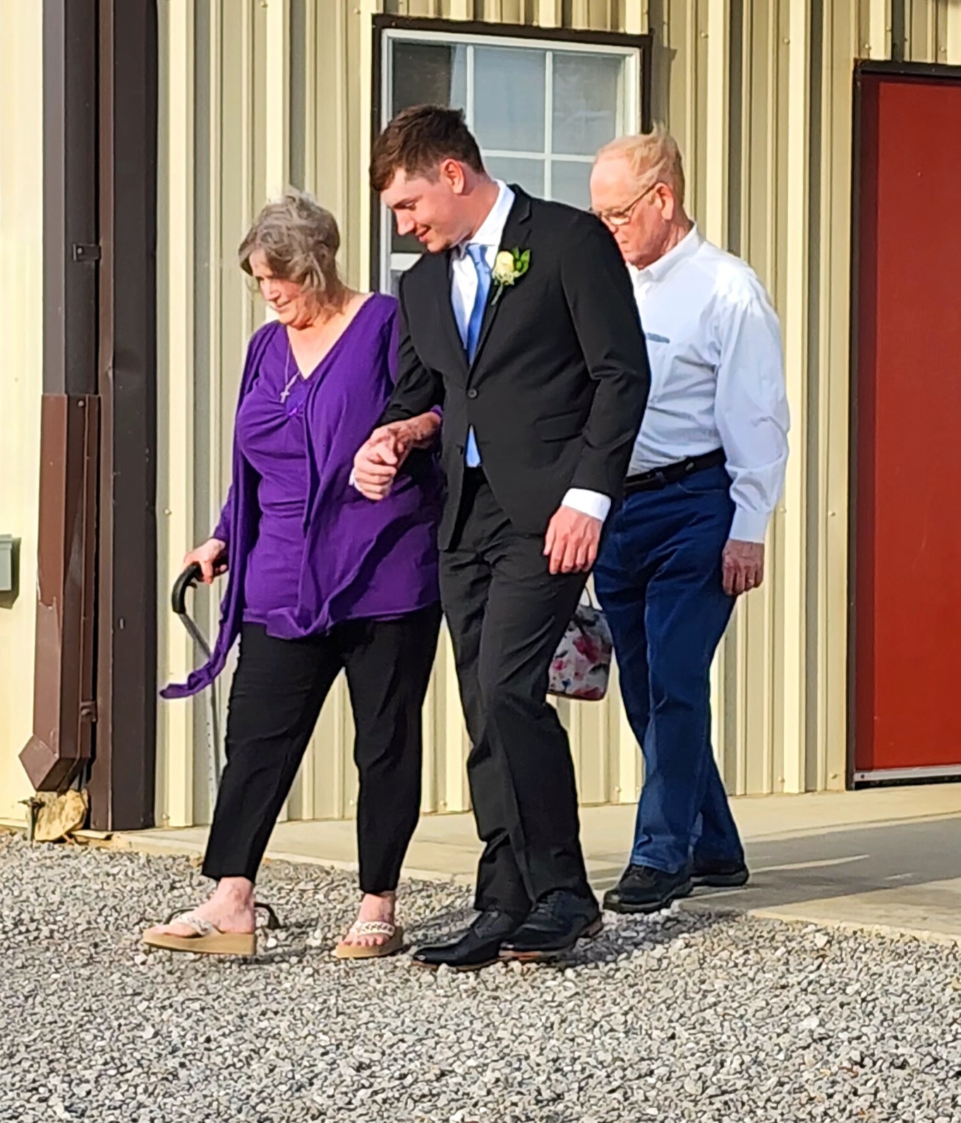 Groom walking his grandparents to their seats before a Texas barn wedding ceremony