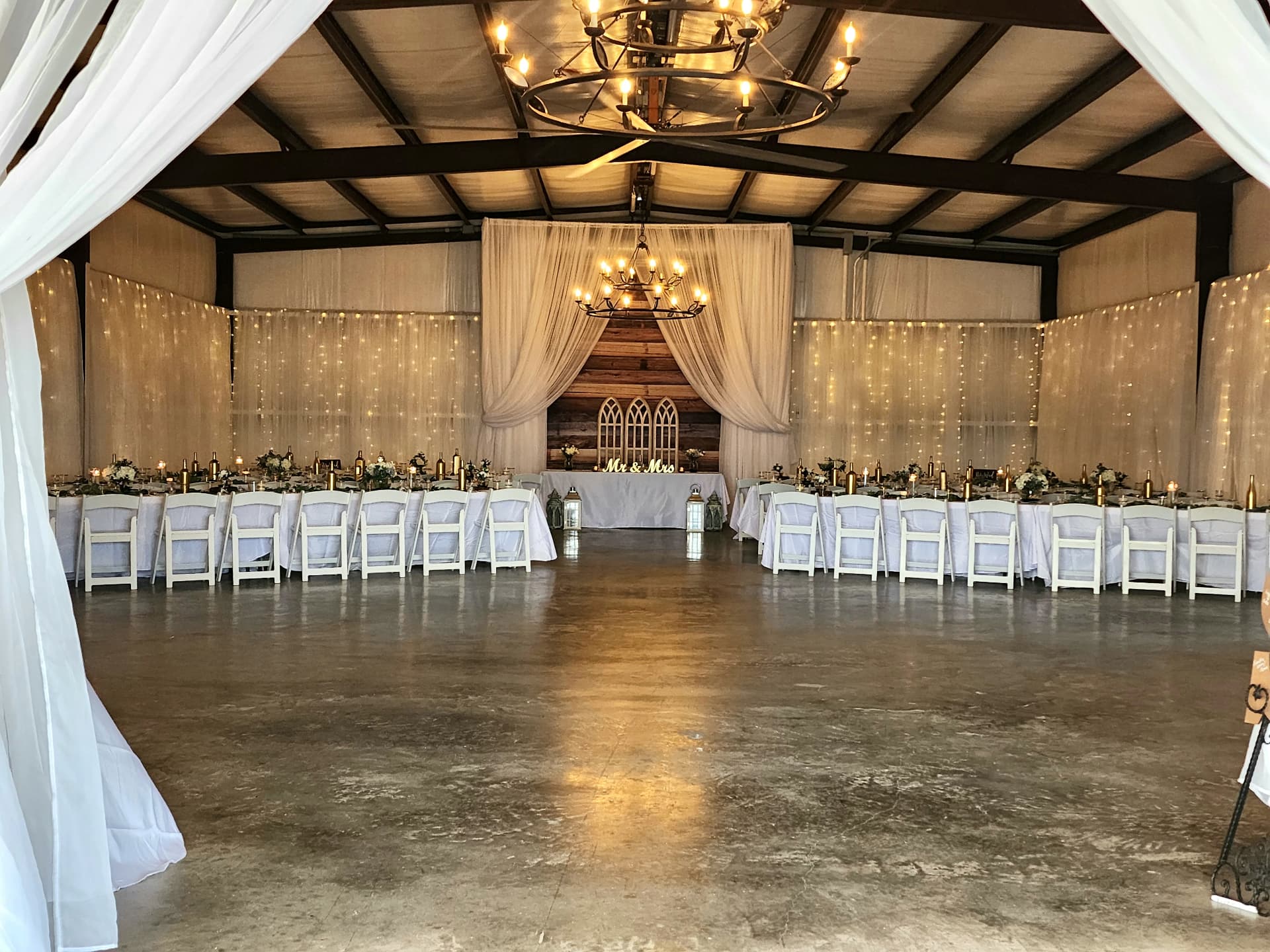 Wide view of long tables set inside the draped barn for a training day near Bryan, Texas