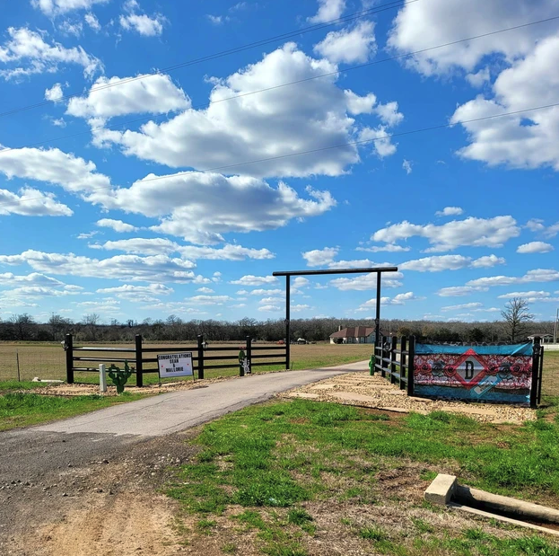 Ranch entrance gate with the Reverie at Diamond D banner at the Normangee, Texas wedding and event venue