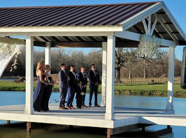 Wedding party standing on the covered lakeside pavilion before the ceremony begins