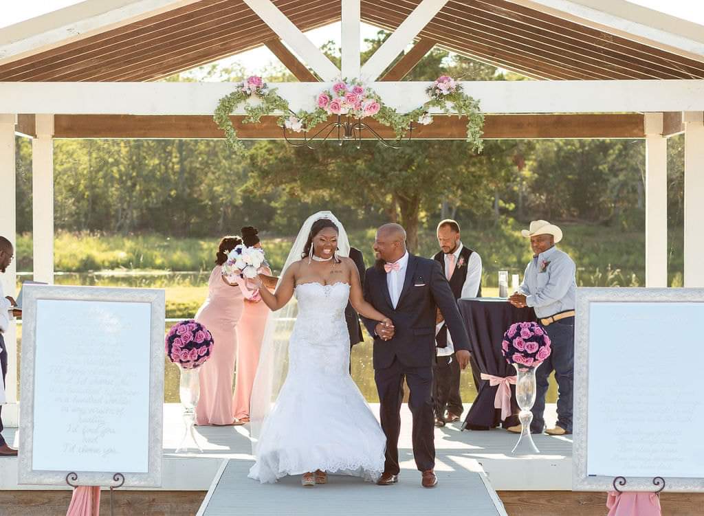 Newlyweds walking hand in hand down the pavilion aisle after their ceremony