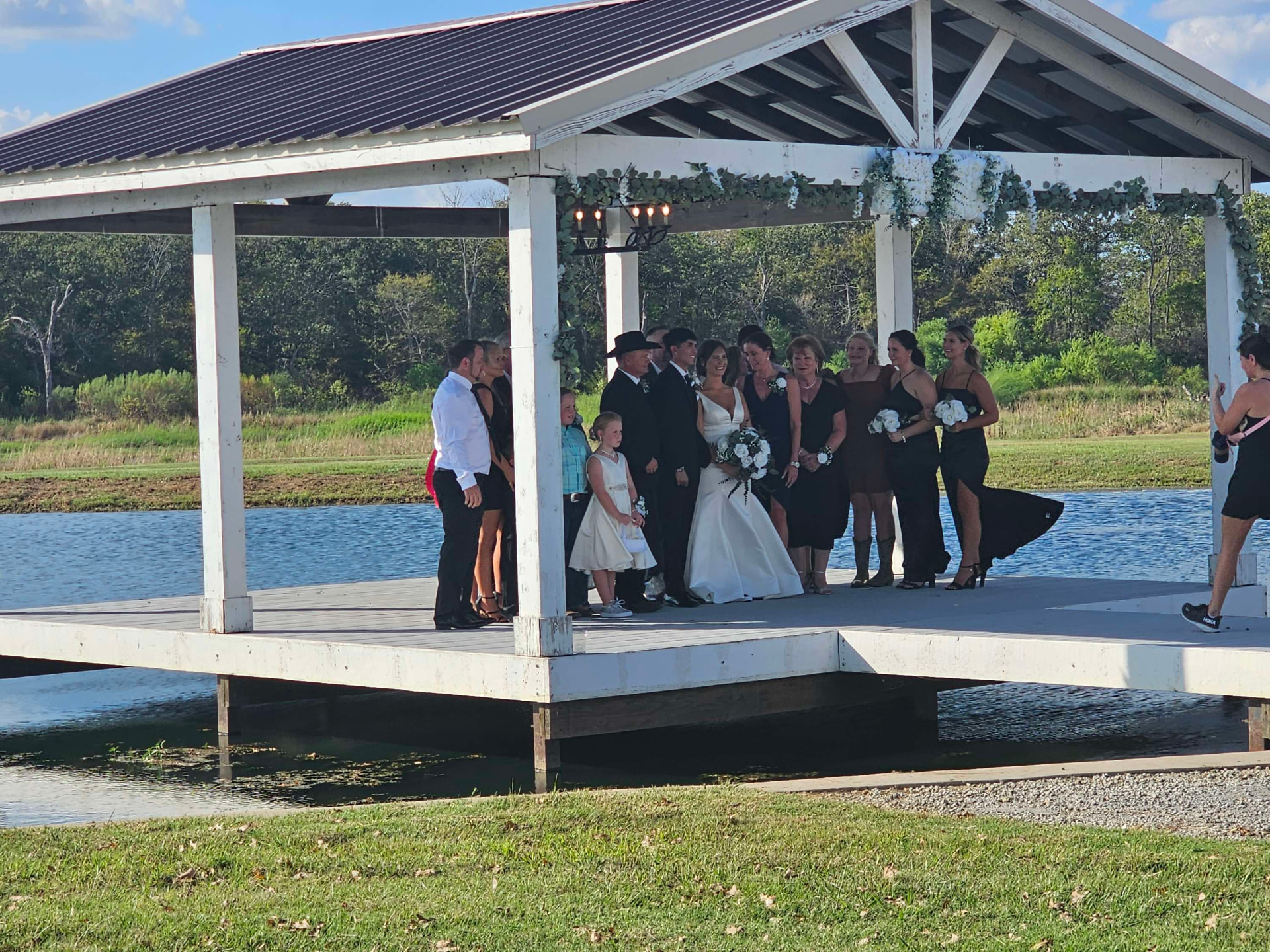 Wedding party portrait on the lakeside pavilion with eucalyptus garland at Reverie at Diamond D