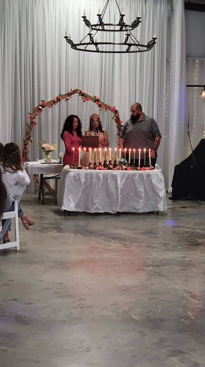 Candle lighting ceremony under the chandelier and floral arch at Bryanna's Sweet 16
