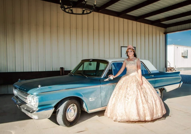 Sweet 16 honoree posing with a vintage teal Mercury under the covered pavilion at Reverie at Diamond D