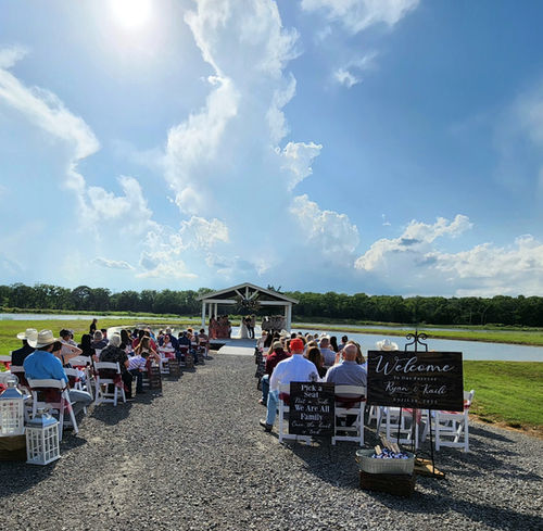 Lakeside ceremony at the pavilion with guests seated along the water at Reverie at Diamond D