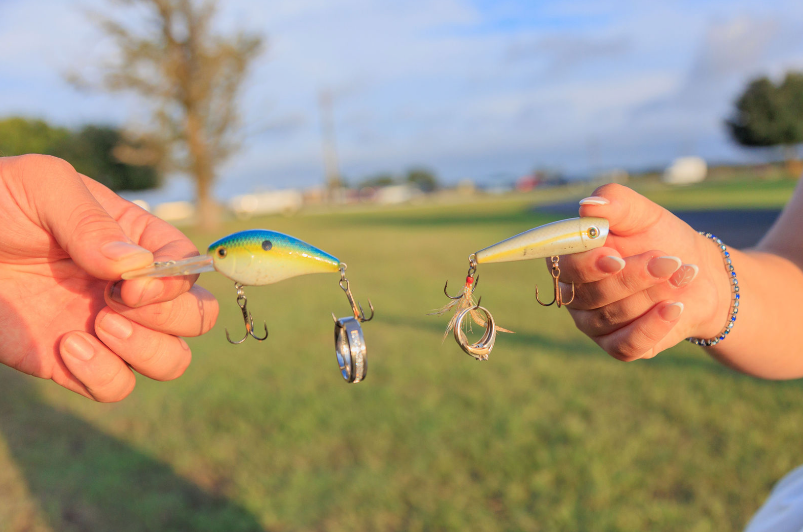 Jaelyn & Keelan's wedding at Reverie at Diamond D — fishing lures with the wedding rings hooked on them, held by the couple