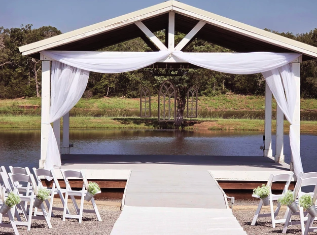 Draped lakeside pavilion set for the Lianna and Austin wedding ceremony at Reverie at Diamond D in Normangee, Texas