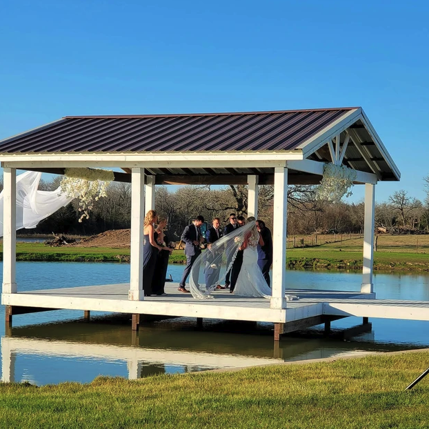 Bride's veil in the breeze during the Sean and Mallorie wedding ceremony on the lakeside pavilion at Reverie at Diamond D