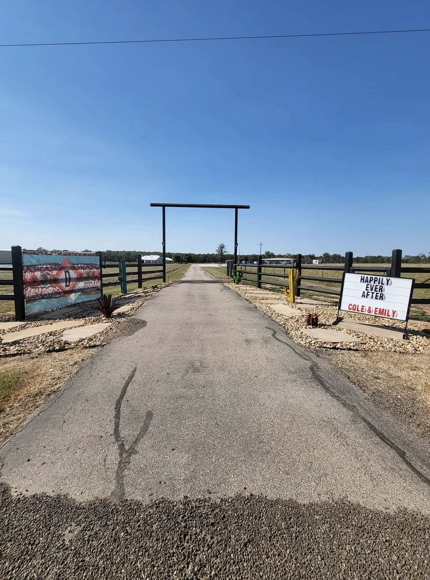 Ranch entrance gate at Reverie at Diamond D with a Happily Ever After Cole and Emily marquee sign on the drive