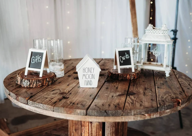 Rustic spool table with Gifts and Cards chalkboard signs, a lantern and a honeymoon fund box