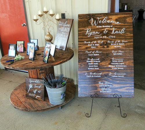 Hand-lettered wooden welcome sign listing the wedding party at Reverie at Diamond D