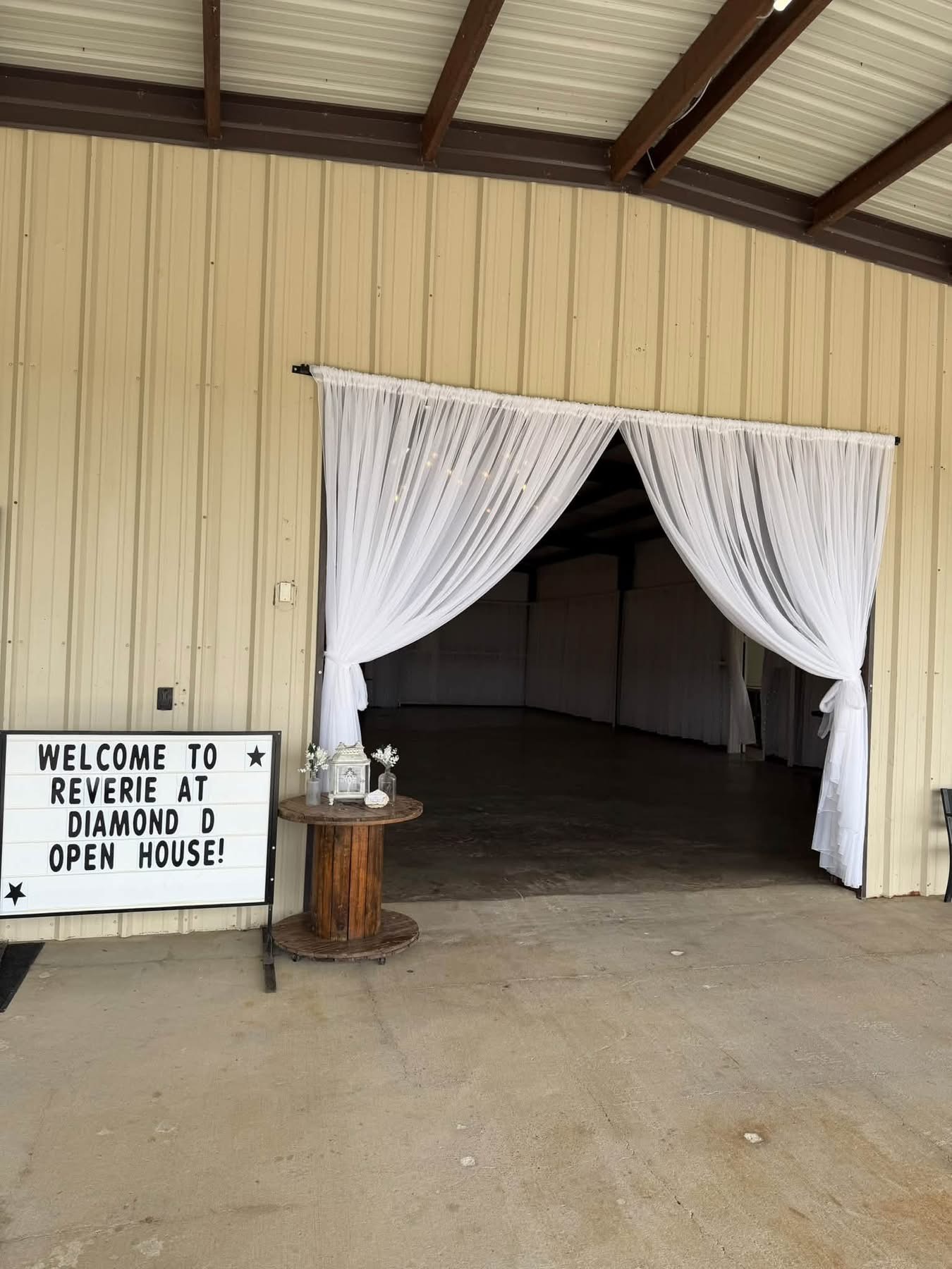 The draped barn entrance and welcome sign at the Reverie at Diamond D Open House in Normangee, Texas
