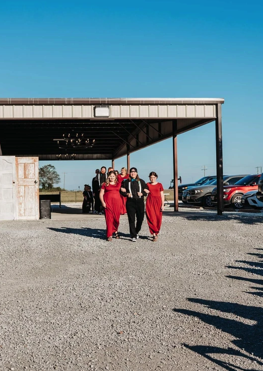 Attendants in red walking out of the covered pavilion for the processional