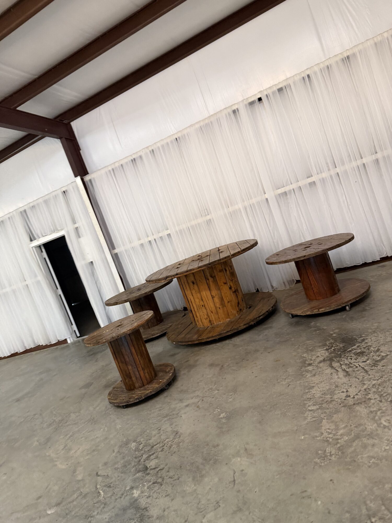 Wooden spool tables from the on-site decor library set up at Reverie at Diamond D in Normangee, Texas