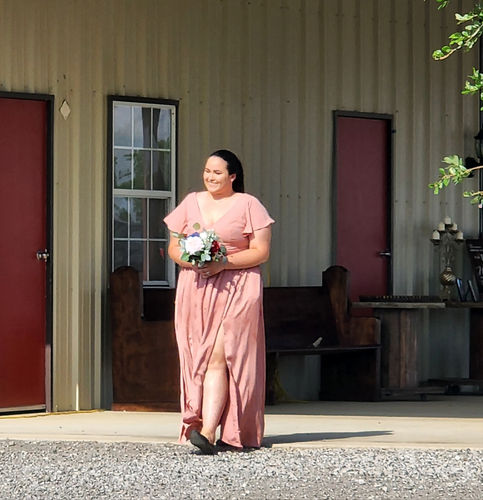 Bridesmaid carrying a bouquet during the wedding processional at Reverie at Diamond D