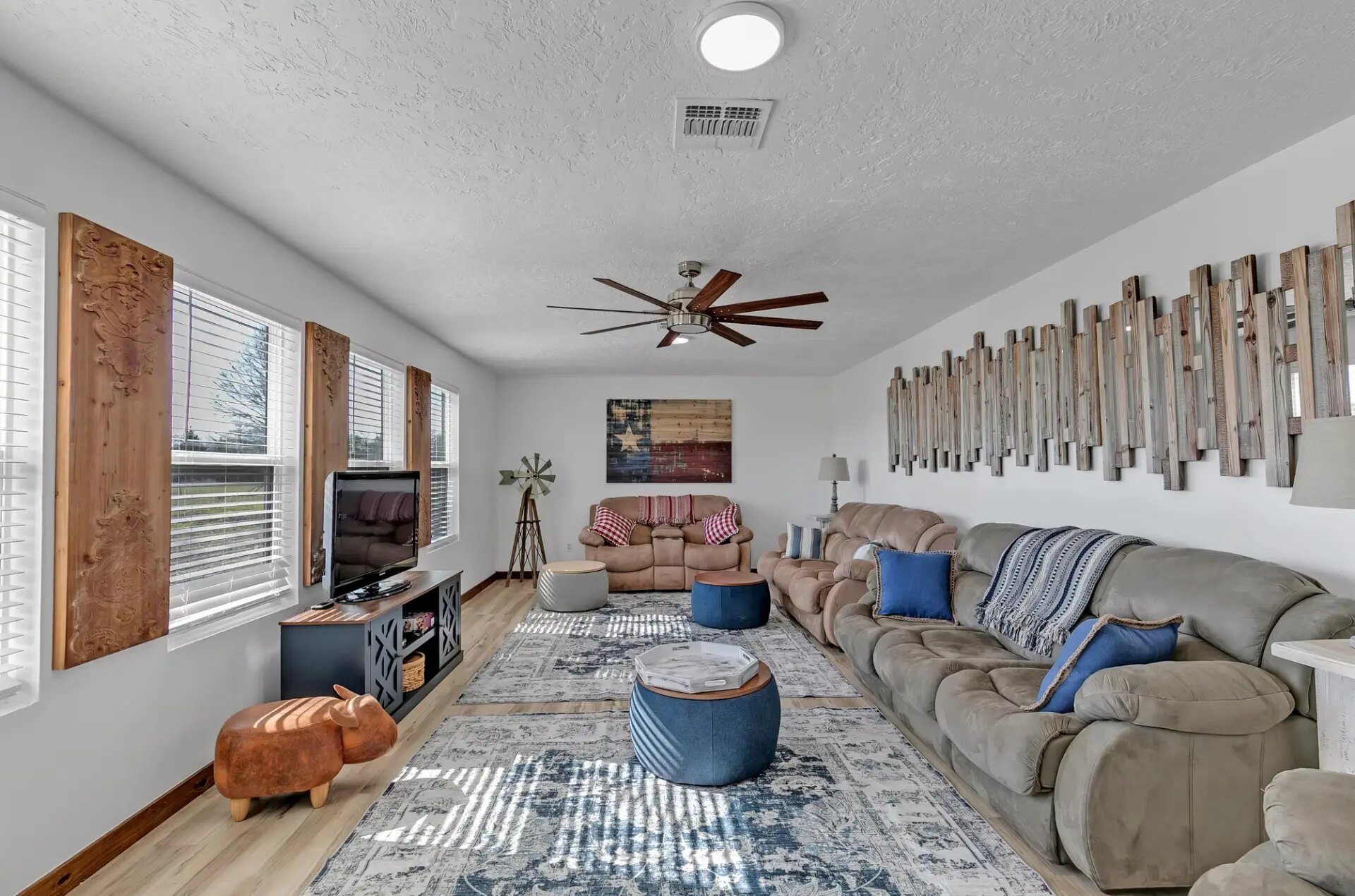 Farmhouse living room with recliners, sofa and a large television, set up for a wedding weekend stay