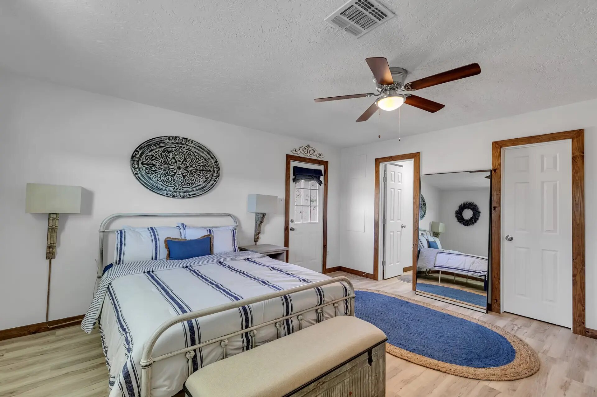 Farmhouse bedroom with iron bed frame, ceiling fan and full-length mirror at Reverie at Diamond D