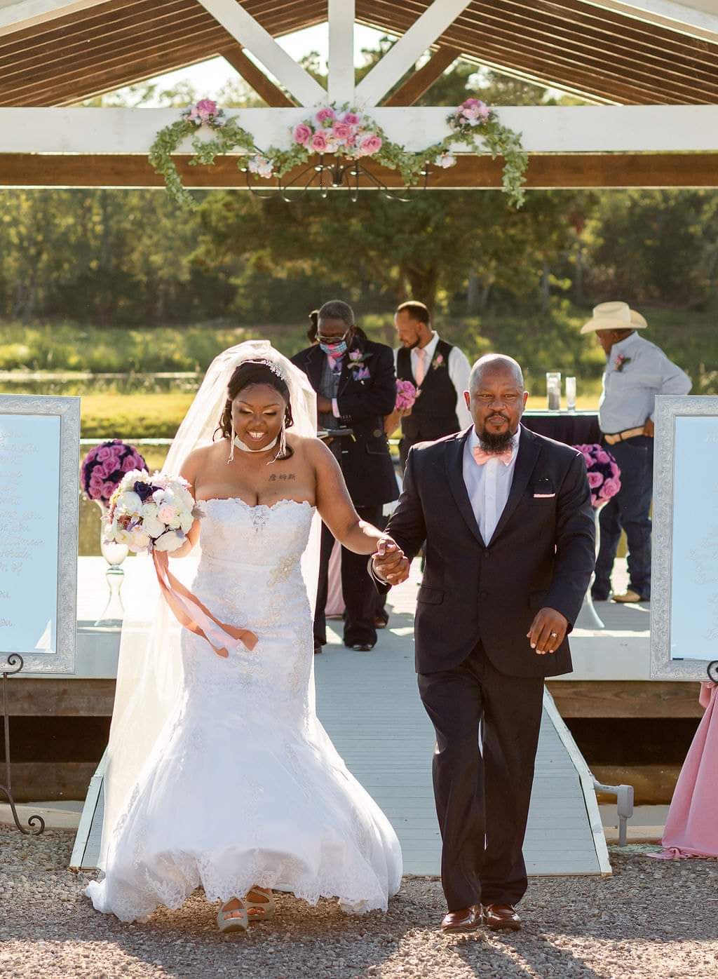 Bride and groom exiting the pavilion aisle holding hands and smiling