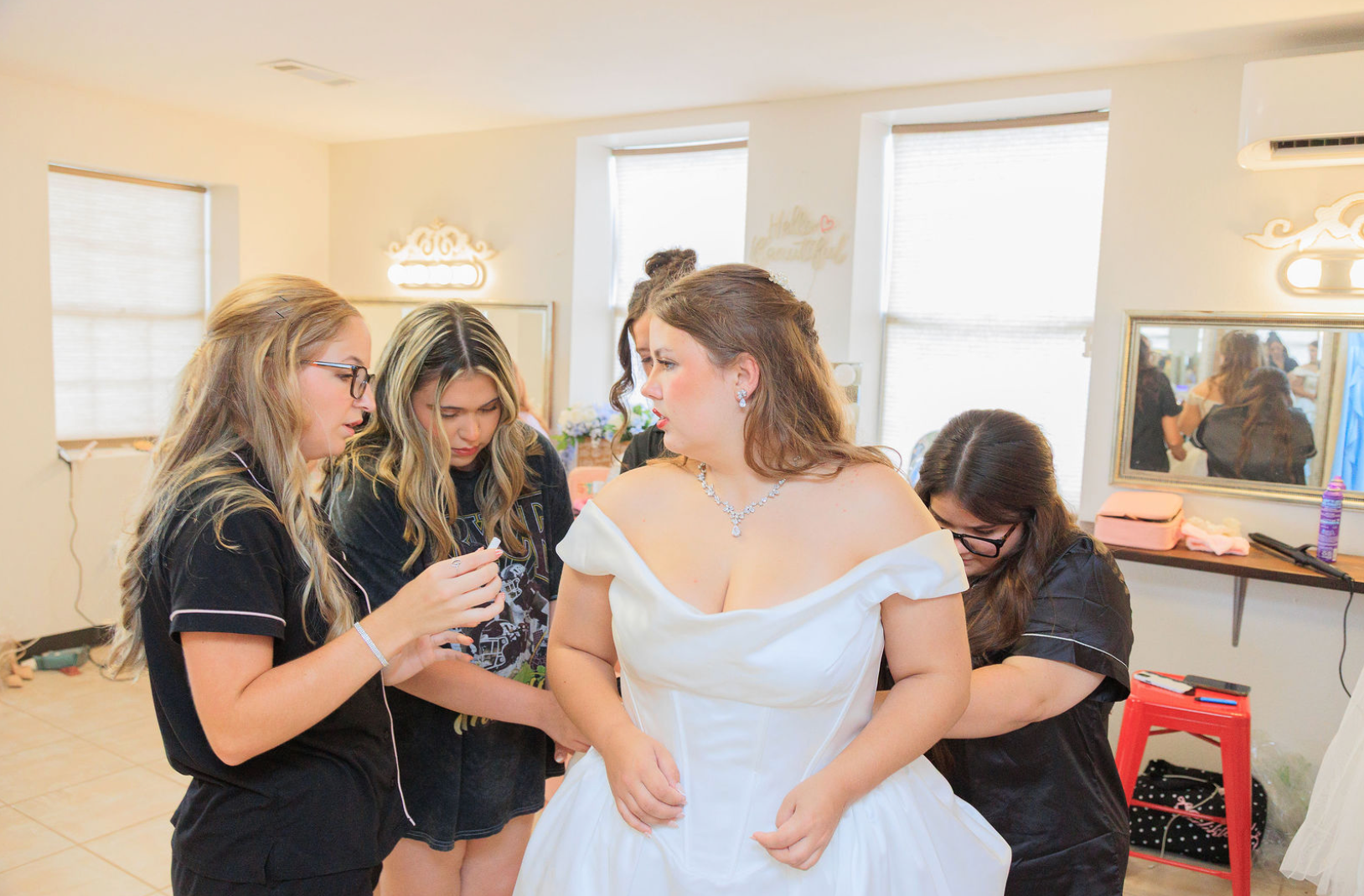 Jaelyn & Keelan's wedding at Reverie at Diamond D — bridesmaids helping the bride into her gown in the bridal suite
