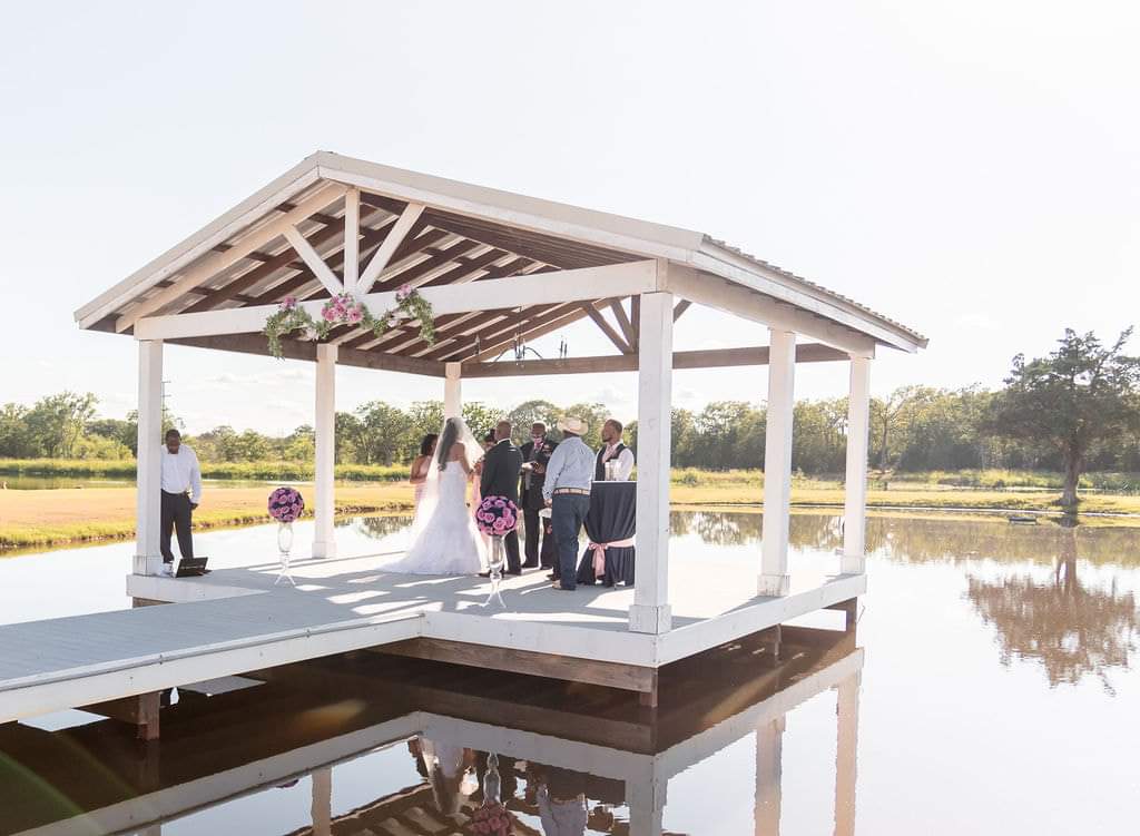 Covered lakeside pavilion set for a ceremony at Reverie at Diamond D event venue in Normangee, Texas