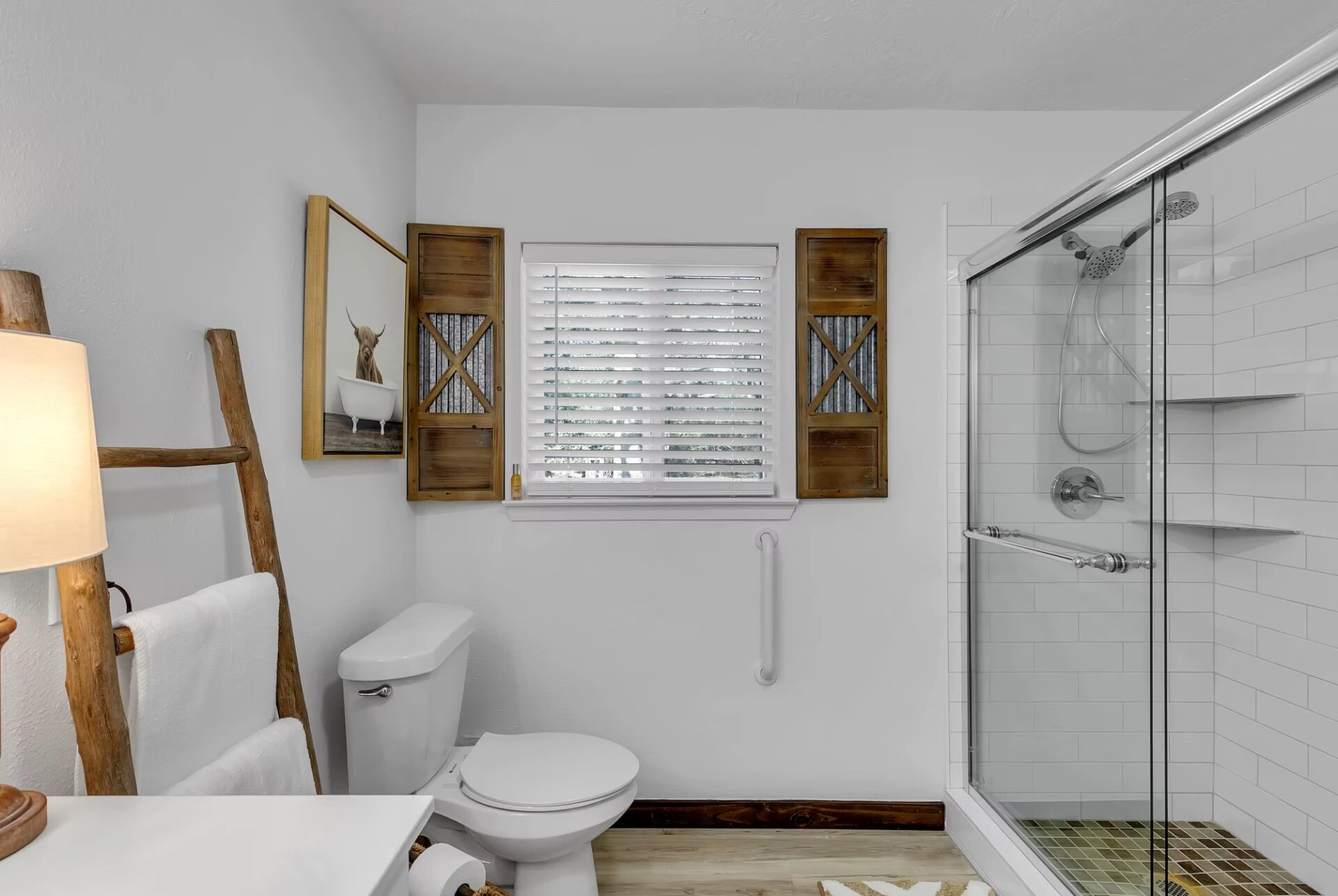 Farmhouse bathroom with walk-in glass shower and reclaimed wood shutters at Reverie at Diamond D