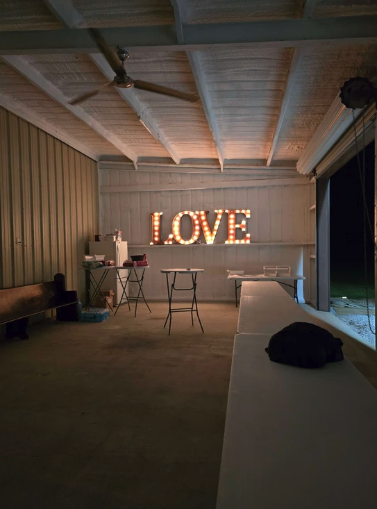 Lighted LOVE marquee sign on the covered patio bar area at Reverie at Diamond D