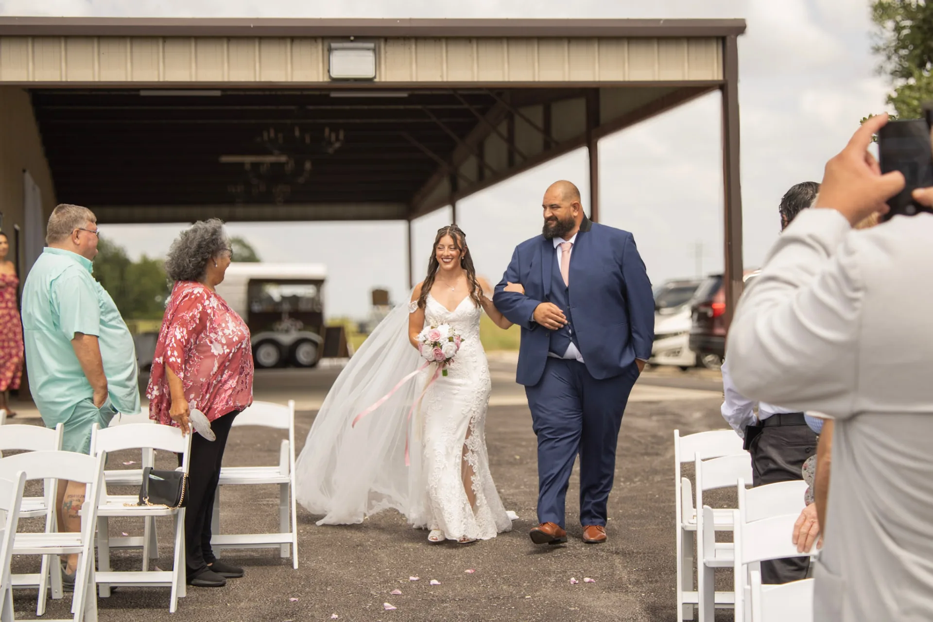 Bryanna walking down the outdoor ceremony aisle with her father at Reverie at Diamond D