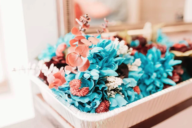 Teal, coral and burgundy silk bouquets waiting in the bridal suite