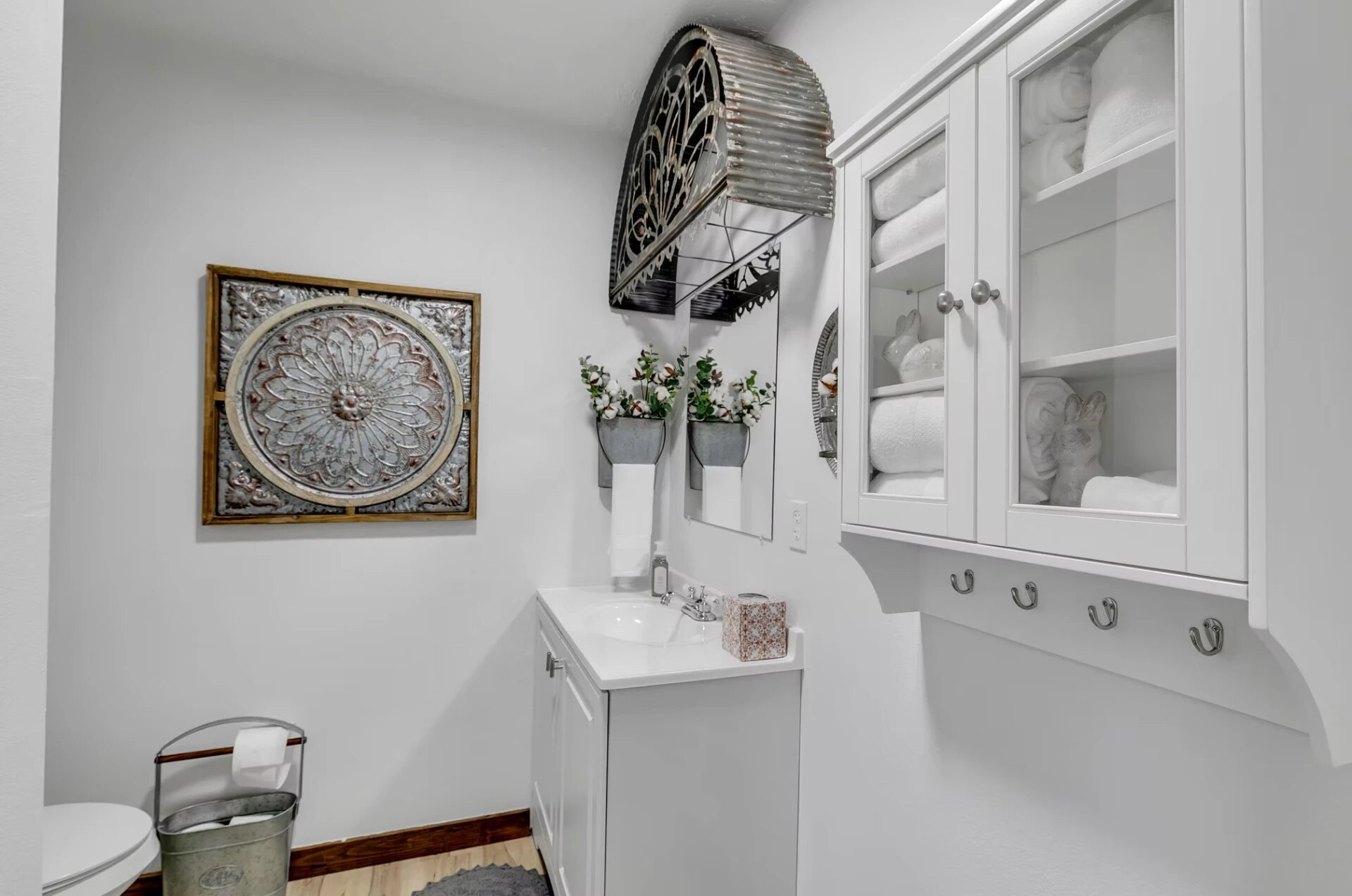 Farmhouse guest bath with fresh towels and vintage tin wall art at Reverie at Diamond D