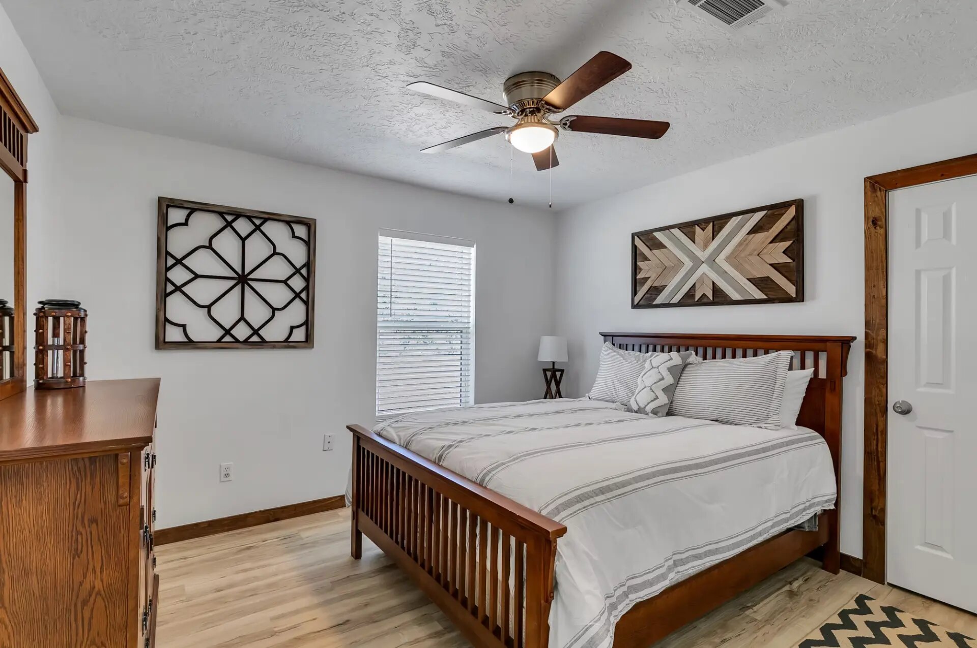 Third farmhouse bedroom with queen bed, dresser and ceiling fan at Reverie at Diamond D