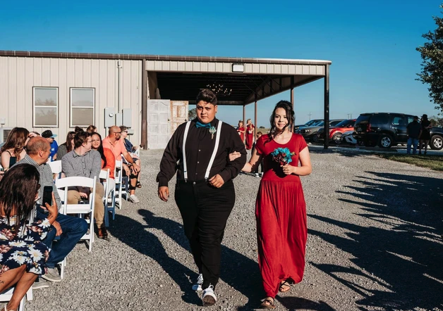 Attendants walking the gravel aisle past seated guests during the processional